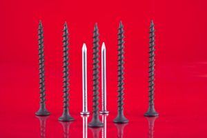 A group of screws and nails standing upright.
